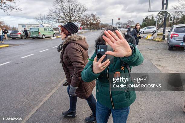 Protester is seen filming journalists, while refusing to be photographed themselve during a protest action against corona-measures where people are...