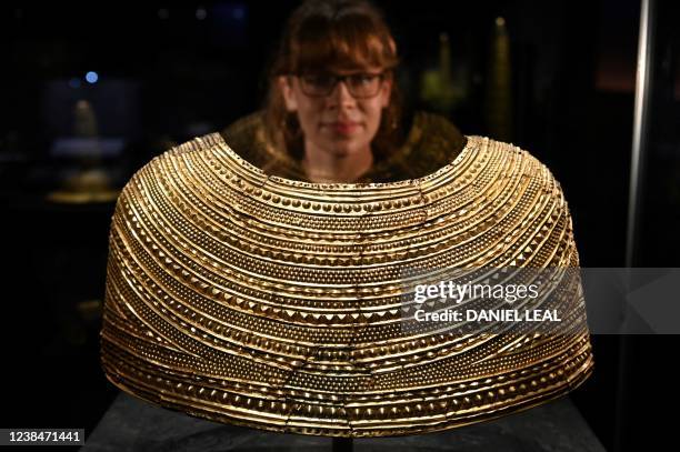 Museum employee looks at a Mold Gold cape dated between 1900-1600 BC and found in Flintshire, Wales, displayed during a press preview of the new...