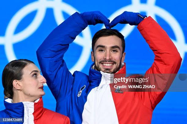 Gold medallist France's Gabriella Papadakis looks on as gold medallist France's Guillaume Cizeron gestures on the podium during the ice dance free...