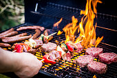 Detail Of Beef Burgers and sausages Cooking On A Barbecue