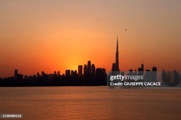 Picture taken on February 14, 2022 shows a general view of the skyline of downtown Dubai with Burj Khalifa at sunset, in the Gulf emirate of Dubai,...