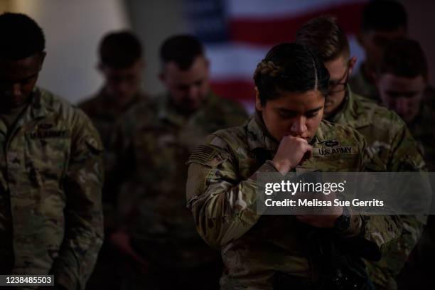 Soldier with the 82nd Airborne division prays with fellow soldiers before boarding a plane to deploy to Poland on February 14, 2022 at Fort Bragg,...