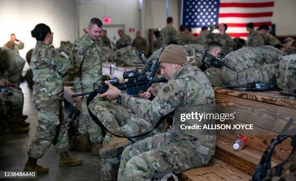 Soldier of the 82nd Airborne Division checks his weapon before deploying to Europe, February 14 in Fort Bragg, North Carolina. - US service members...