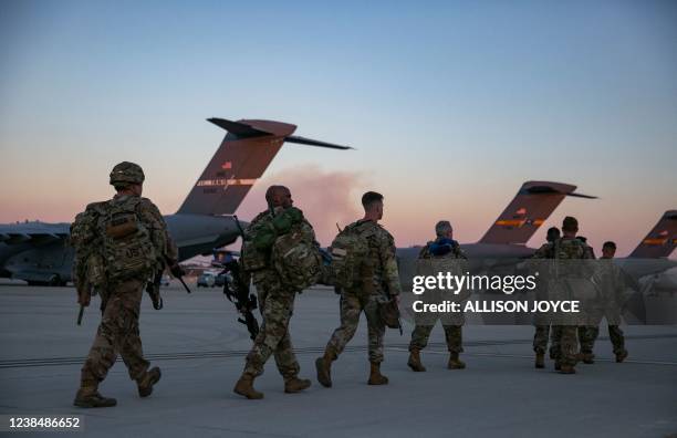 Soldiers of the 82nd Airborne Division walk to board a plane from Pope Army Airfield in Fort Bragg, North Carolina on February 14, 2021 as they are...