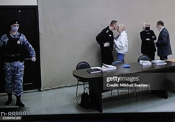 Russian opposition politician Alexei Navalny and his wife Yulia seen on the screen at the prison colony court during the trial on February 15, 2022...