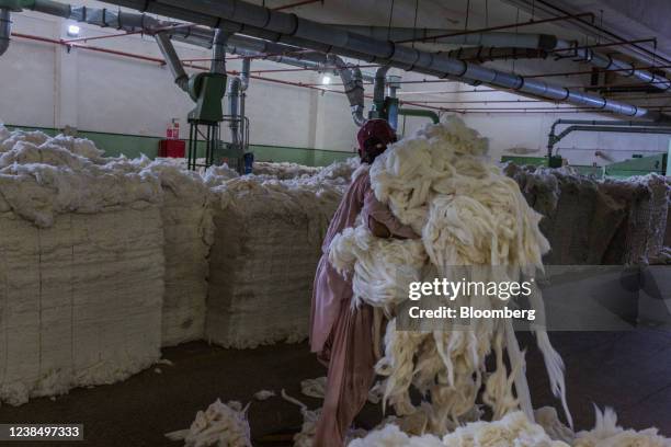 Worker carries blended cotton inside a blow-room unit at a Gadoon Textile Mills Ltd. Factory in Karachi, Pakistan, on Saturday, Feb. 12, 2022....