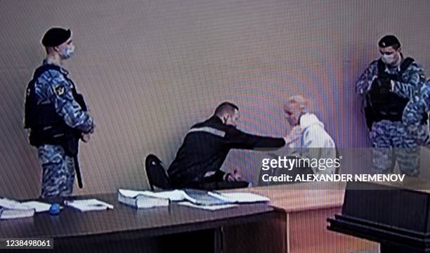 Photograph taken from a TV screen during live broadcast of the court hearing at the penal colony N2 shows Kremlin critic Alexei Navalny speaking with...
