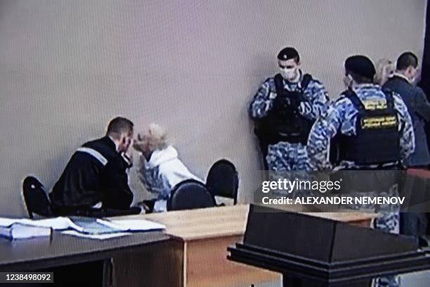 Photograph taken from a TV screen during live broadcast of the court hearing at the penal colony N2 shows Kremlin critic Alexei Navalny speaking with...