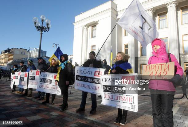 People holding banners and flags attend anti-vaccine protest outside the Ukrainian Parliament in Kiev, Ukraine, on February 15, 2022. Opponents of...