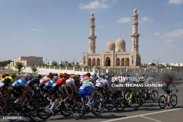 The peloton rides during the sixth stage of the Oman Tour, between al-Mouj Muscat and Matrah Corniche, in Muscat on February 15, 2022.
