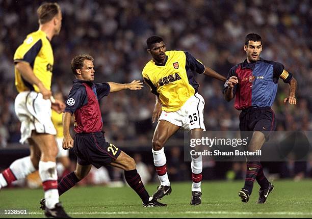 Nwankwo Kanu of Arsenal is closed down by Frank de Boer and Josep Guardiola of Barcelona during the Barcelona v Arsenal UEFA Champions League Group B...