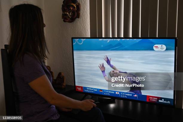 Woman watches a very emotional performance by the Russian ice skater, Kamila Valieva, competing in the women's singles event at the Beijing Winter...