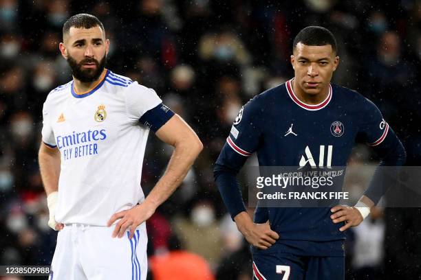 Paris Saint-Germain's French forward Kylian Mbappe and Real Madrid's French forward Karim Benzema stand on the pitch during the UEFA Champions League...