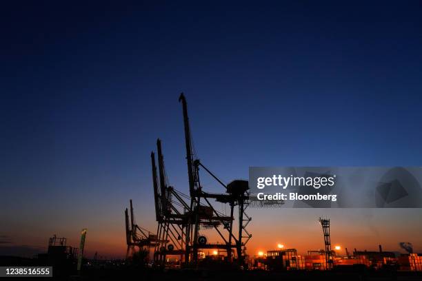 Containers next to gantry cranes at a shipping terminal in Yokohama, Japan, on Monday, Feb. 14, 2022. Japan is scheduled to release trade balance...