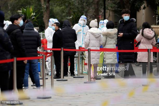 Residents queue to undergo nucleic acid tests for the Covid-19 coronavirus at a residental area in Suzhou in China's eastern Jiangsu province on...
