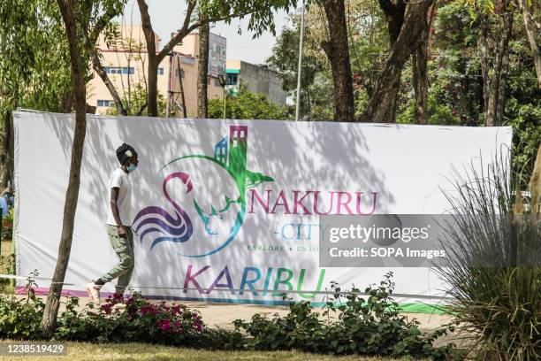 Man walks past a banner of Nakuru City at Nyayo Garden in the Central Business District. Nakuru municipality was upgraded to city status by President...