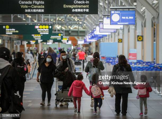Travelers are seen at the departure hall of Vancouver International Airport in Richmond, British Columbia, Canada, on Feb. 15, 2022. Canada is easing...