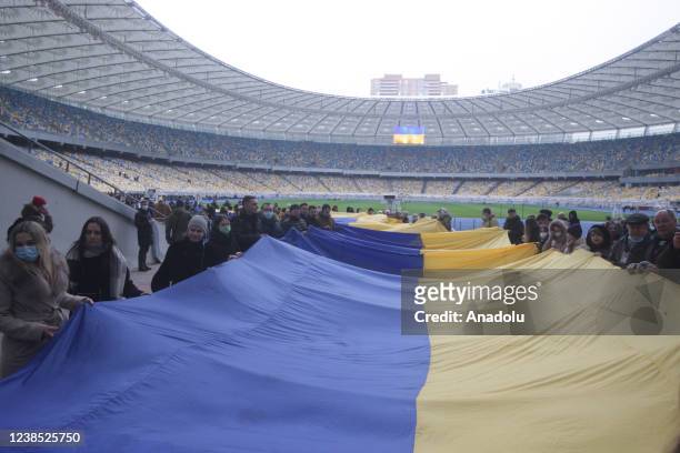 People attend an event to the Day of Unity at the Olimpiysky stadium in Kiev, Ukraine, on February 16, 2022. Participants unfurled the largest flag...