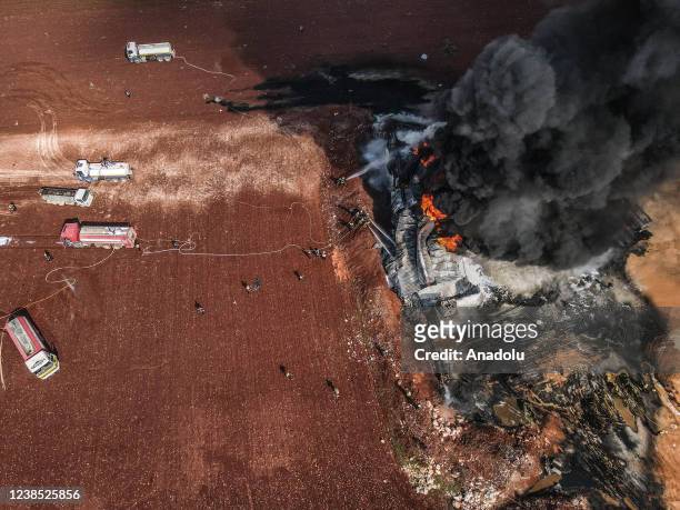 Firefighters try to extinguish a fire broke out on a fuel depot after an attack carried out by the Assad regime and Iranian-backed foreign terrorist...