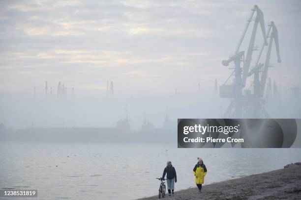 Couple walks on a beach near the port of Berdyansk on the Azov Sea on February 16, 2022 in Berdyansk, Ukraine. Russian forces are conducting...