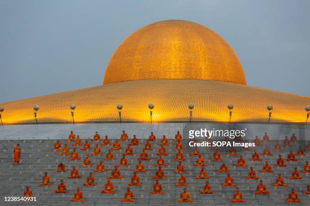 Monks are pictured meditating at Dhammakaya Temple during the Makha Bucha ceremony in Phatum Thani. Makha Bucha Day, Dhammakaya temple held a virtual...