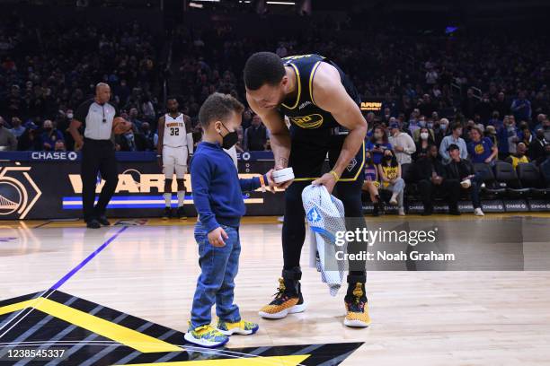 The son of Stephen Curry of the Golden State Warriors presents him with the NBA All-Star ring before the game against the Denver Nuggets on February...