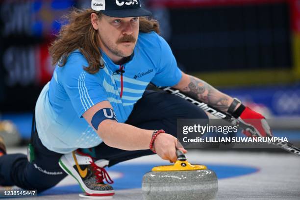 S Matt Hamilton curls the stone during the men's round robin session 12 game of the Beijing 2022 Winter Olympic Games curling competition between...