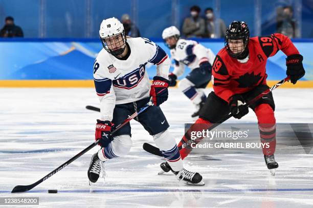 S Jessica Compher controls the puck during the women's gold medal match of the Beijing 2022 Winter Olympic Games ice hockey competition between...