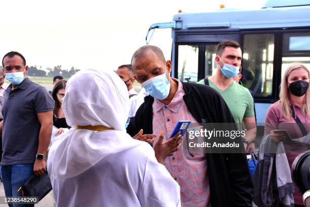 Airport staff scans tourists with EDE device after they arrive at Abeid Amani Karume International Airport in Zanzibar Island, Tanzania on February...