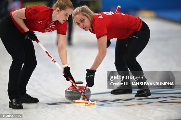 Denmark's Mathilde Halse and Denise Dupont sweep during the women's round robin session 12 game of the Beijing 2022 Winter Olympic Games curling...