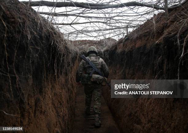 Serviceman of Ukrainian Military Forces walks along trench on his position on the front line with Russia backed separatists not far Novolugansk,...