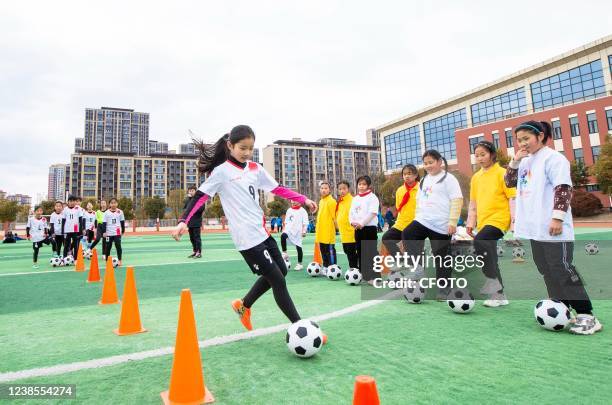 Children of a girls' soccer club at a primary school practice basic skills during after-school service hours in Hai 'an, East China's Jiangsu...