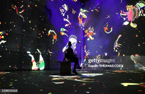 People visit the Atelier des Lumieres, in Paris on February 17, 2022 during a press preview of the exhibition titled "Kandinsky, abstract odyssey"...