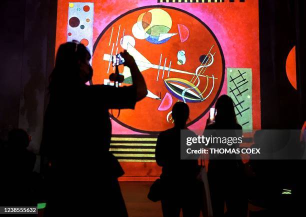 People visit the Atelier des Lumieres, in Paris on February 17, 2022 during a press preview of the exhibition titled "Kandinsky, abstract odyssey"...