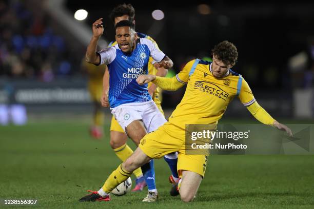 Tom Holmes of Reading challenges Nathan Thompson of Peterborough United during the Sky Bet Championship match between Peterborough United and Reading...