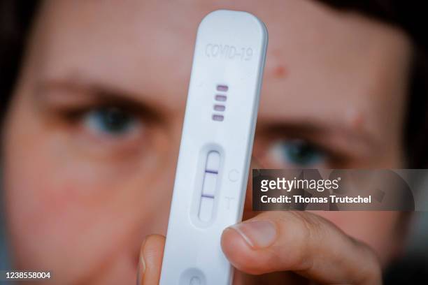 In this photo illustration a woman holds a positive SARS-CoV-2 Rapid Ag Antigen rapid test on February 17, 2022 in Berlin, Germany.