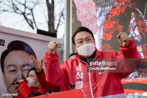 Yoon Suk-yeol, center, the presidential candidate of the main opposition People Power Party, waves his hands during a presidential election campaign...