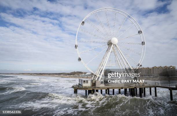 Picture taken on February 17, 2022 in The Hague, Netherlands shows the Ferris wheel gondolas being removed at the pier of Scheveningen as a...