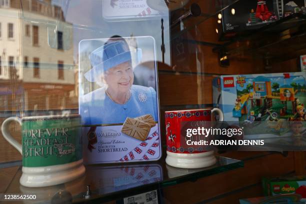 Britain's Queen Elizabeth II is featured on the cover of a biscuit tin seen in the window of a souvenir shop in Windsor on February 17, 2022. -...