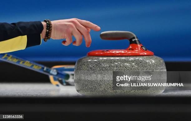 Sweden's Niklas Edin curls the stone during the men's semifinal game of the Beijing 2022 Winter Olympic Games curling competition against Canada at...