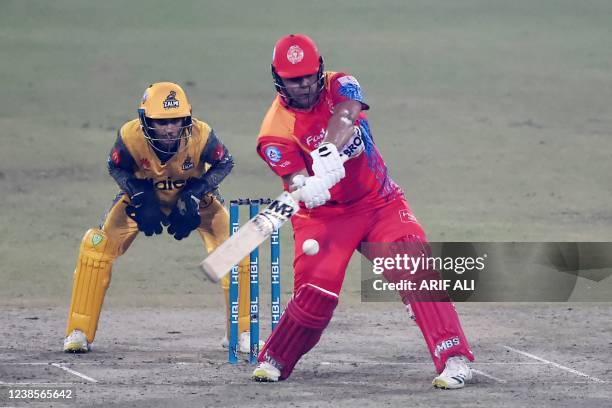 Islamabad United's Azam Khan plays a shot as Peshawar Zalmi's wicketkeeper Mohammad Haris watches during the Pakistan Super League Twenty20 cricket...