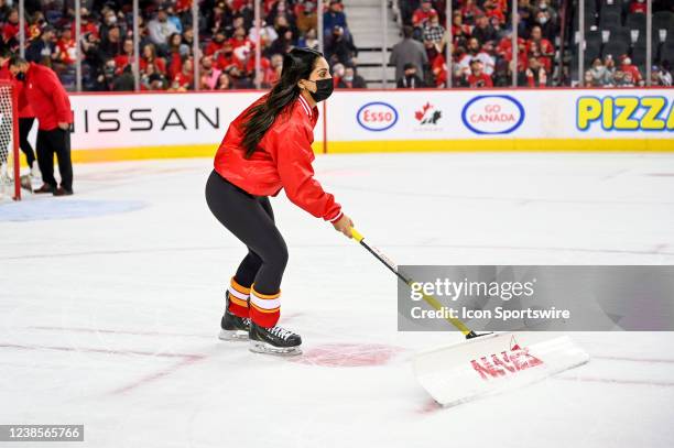 Calgary Flames ice crew members clean the ice between whistles during the first period of an NHL game where the Calgary Flames hosted the Anaheim...