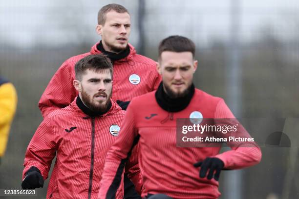 Ryan Manning, Ryan Bennett and Matt Grimes warm up during the Swansea City Training Session at The Fairwood Training Ground on February 17, 2022 in...