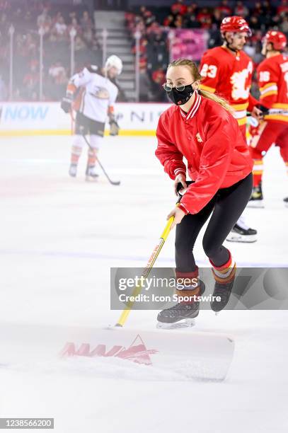 Calgary Flames ice crew members clean the ice between whistles during the first period of an NHL game where the Calgary Flames hosted the Anaheim...