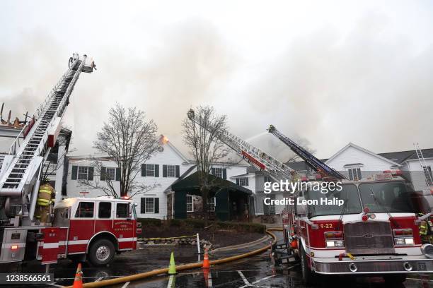 Tower ladders pour water on a massive fire at the Oakland Hills Country Club on February 17, 2022 in Bloomfield Hills, Michigan. The fire started...