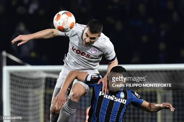 Olympiakos' Greece's defender Sokratis Papastathopoulos jumps for the ball with Atalanta's Colombian forward Luis Muriel during the UEFA Europa...