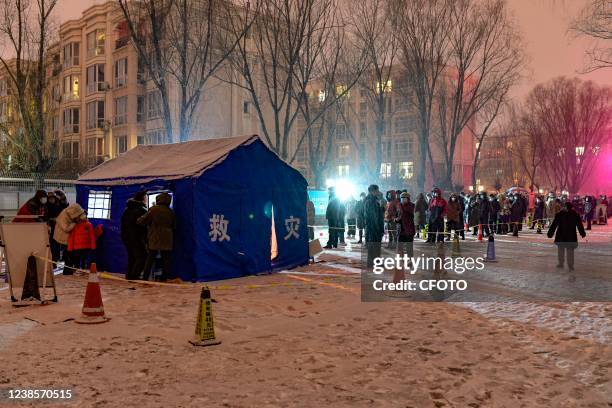 Residents wait in line for nucleic acid testing at a nucleic acid sampling site in Hohhot, Inner Mongolia, China, on The evening of February 17, 2022.