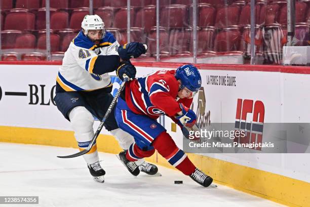 Robert Bortuzzo of the St. Louis Blues and Artturi Lehkonen of the Montreal Canadiens skate after the puck along the boards during the second period...