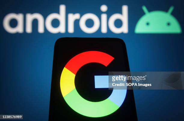 In this photo illustration, a Google logo is displayed on a smartphone screen with the Android logo in the background. .