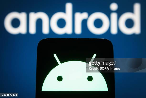 In this photo illustration, Android logo is displayed on a smartphone screen and in the background.